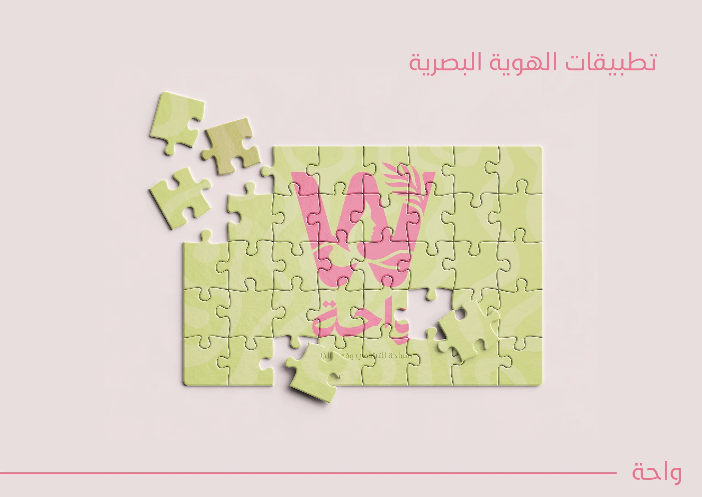 أحجية صور مقطوعة خضراء مطبوع عليها الشعار الوردي، وبعض قطعها متناثرة.