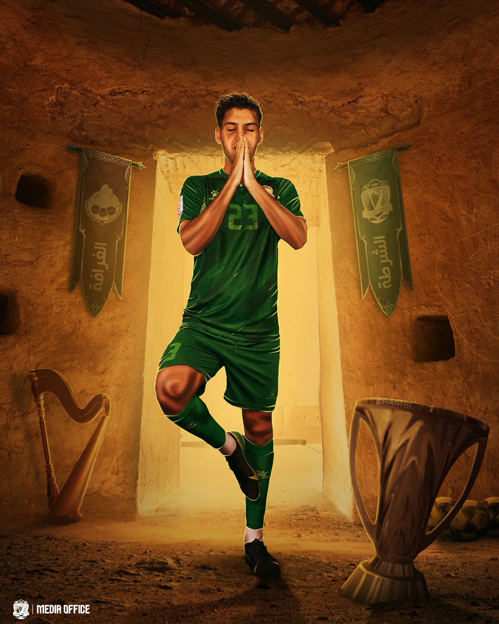 لاعب بقميص الشرطة الأخضر رقم 23 يقف على ساق واحدة ضامّاً كفّيه في غرفة طينية، بين رايتَين وقيثارة وكأس.