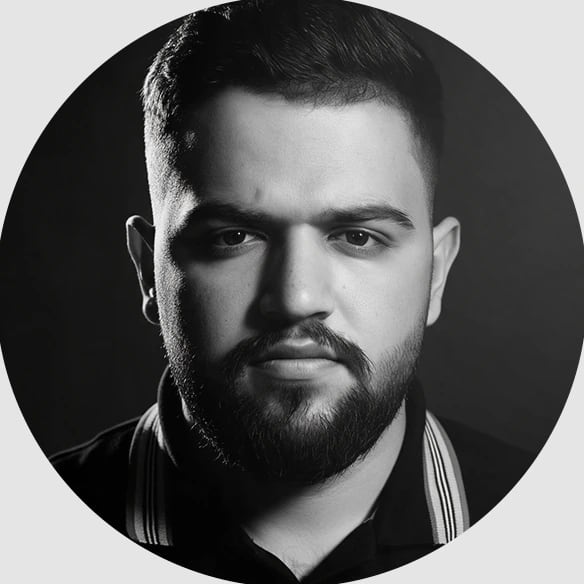 صورة شخصية بالأبيض والأسود لعبدالرحمن صدام على خلفية داكنة.
