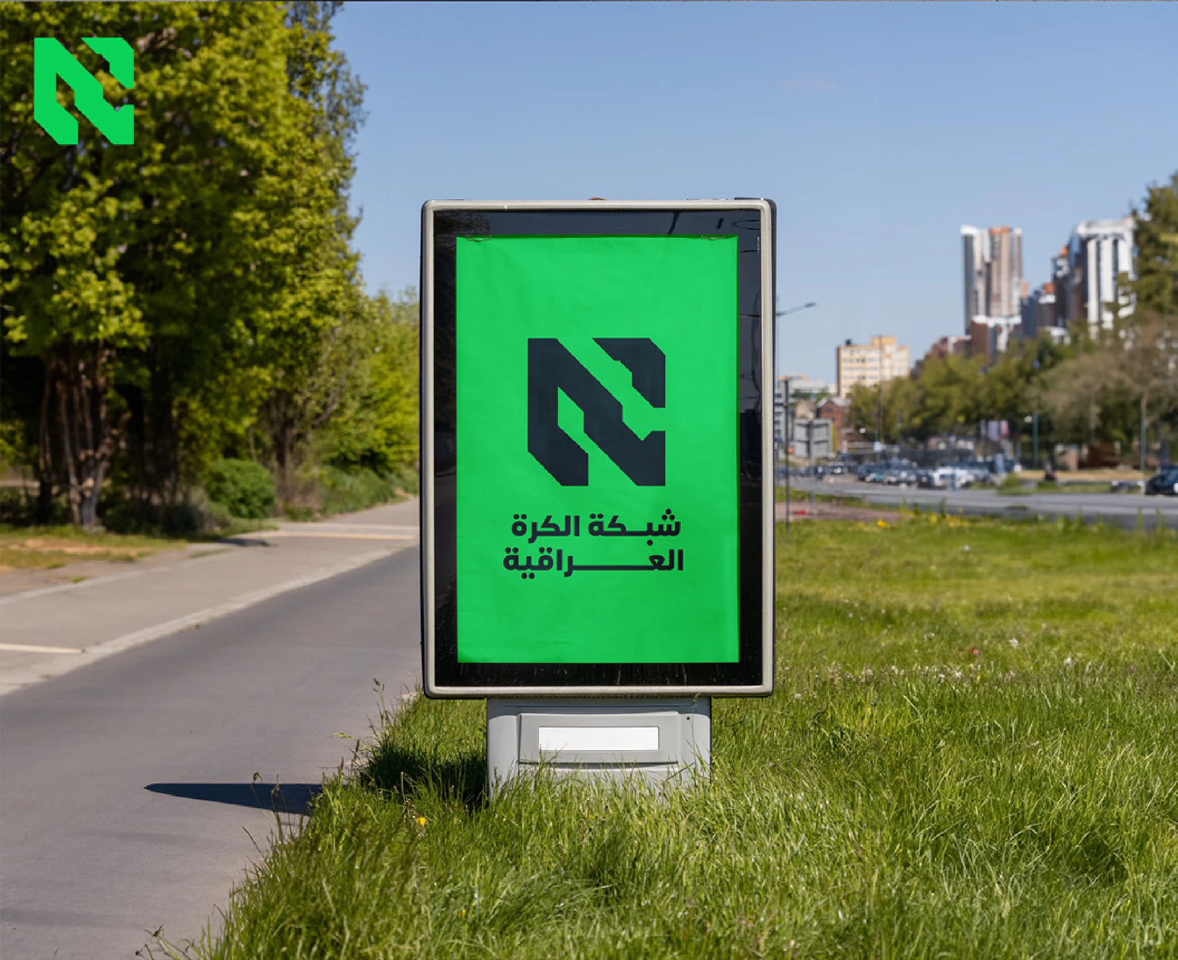 لوحة إعلانية في الشارع بجانب طريق تعرض الشعار واسم الشبكة بالعربية على خلفية خضراء.